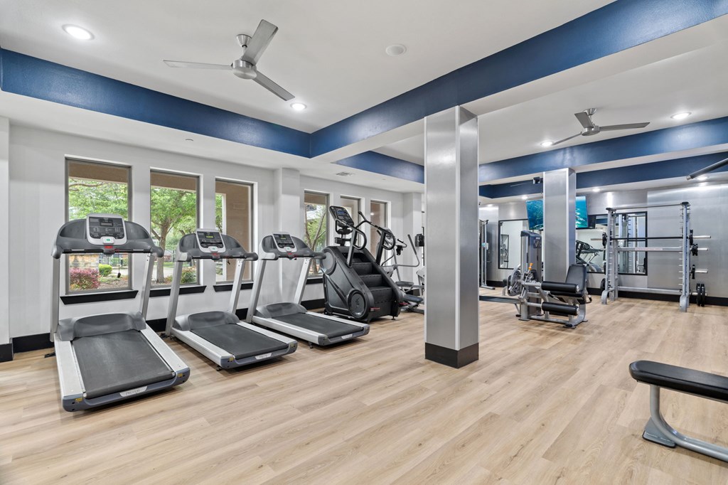 A gym with treadmills, weights, and exercise equipment.