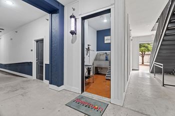 A hallway with a blue wall and a sign on the floor.