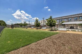 a grassy area with trees and a building in the background