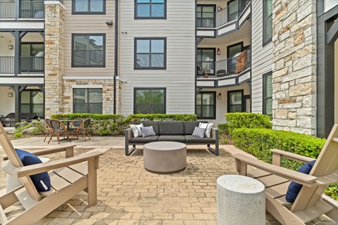 A patio with a table and chairs in front of a building.