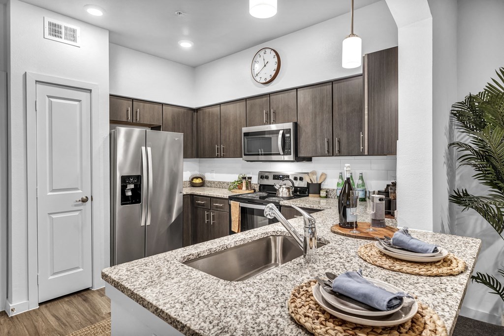 a kitchen with granite counter tops and stainless steel appliances