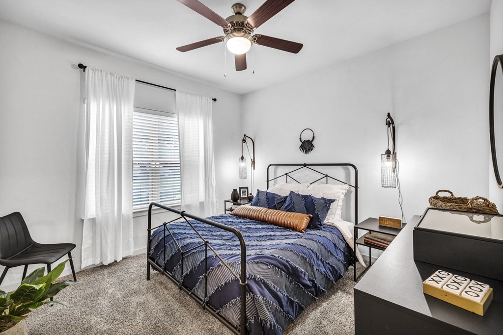 a bedroom with a bed and a ceiling fan