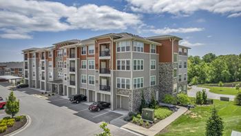 an aerial view of an apartment complex with cars parked in a parking lot