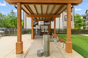 A wooden pergola with a metal pole and a bench underneath it.