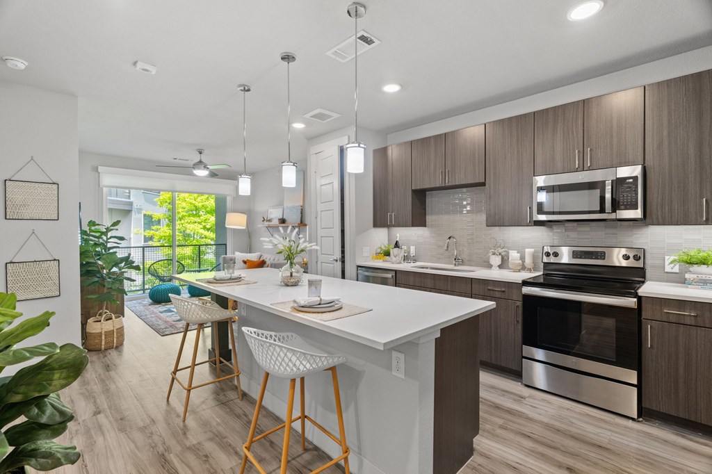 A modern kitchen with a large island and stainless steel appliances.