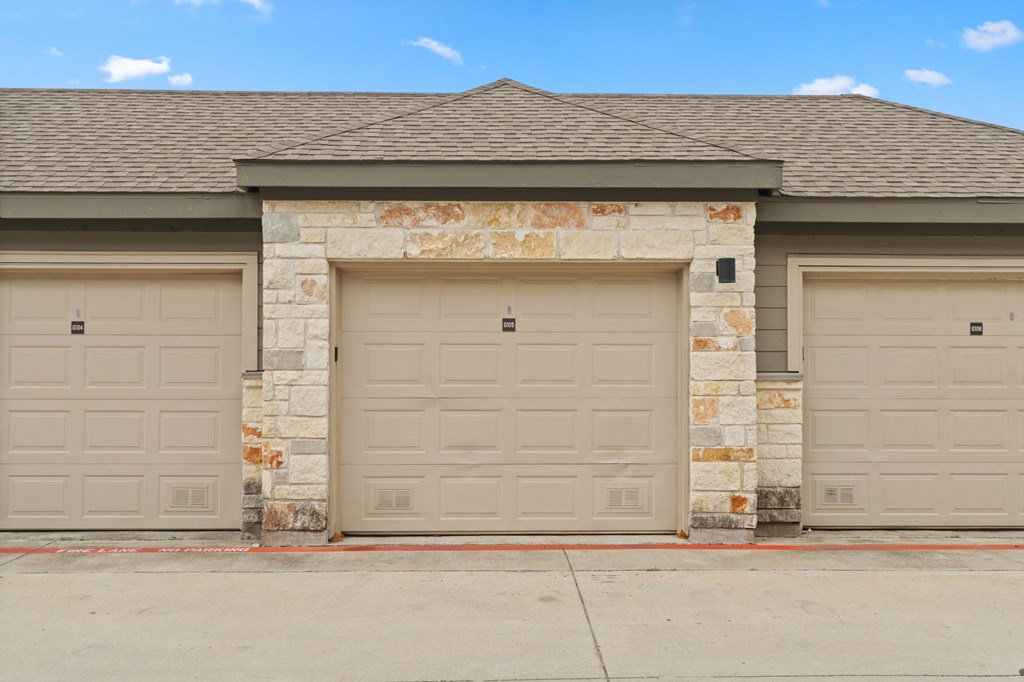 A house with two garage doors and a stone pillar.