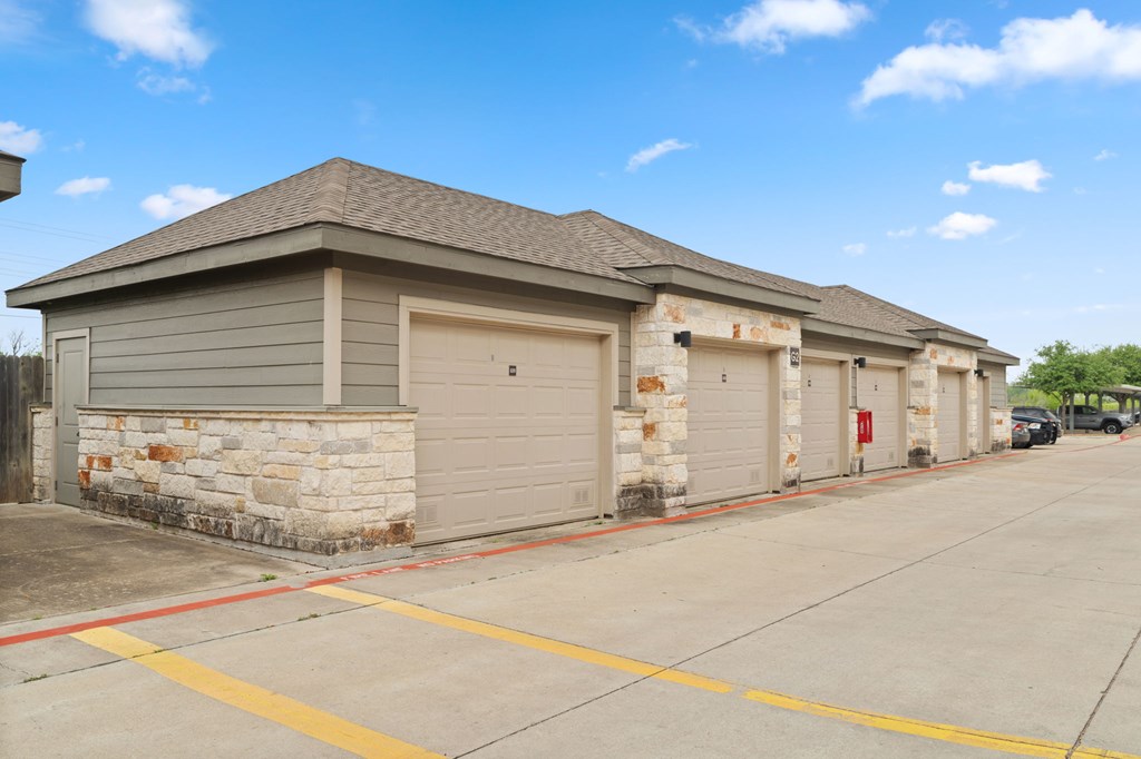 A building with a grey roof and a stone pillar on the left side.