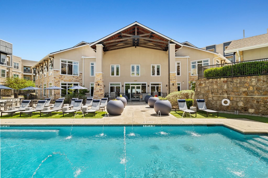 A large building with a pool in front of it.