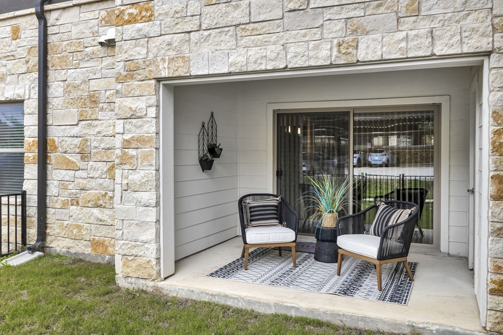 two chairs on a porch in front of a garage door