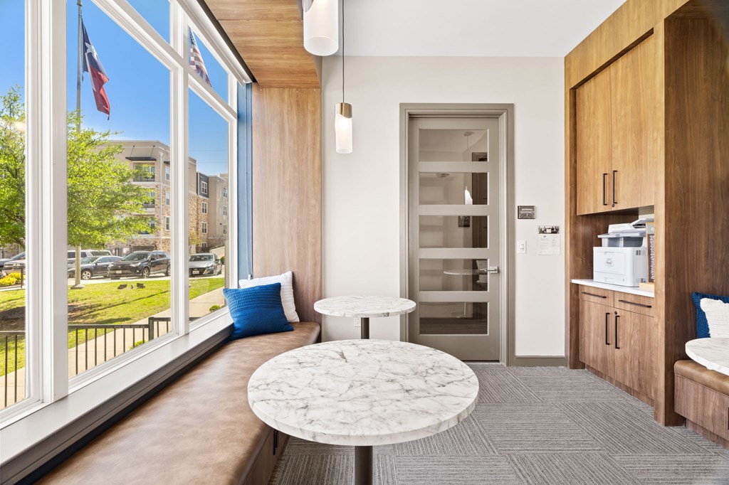 A white marble table is in the middle of a room with a window and a door.
