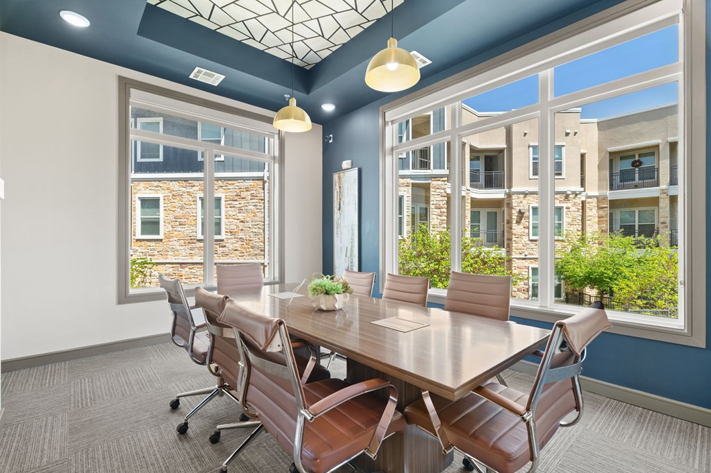A conference room with a long table and chairs.