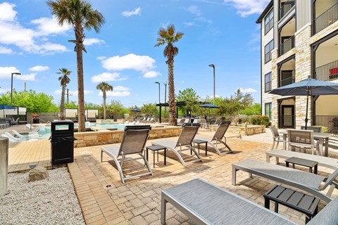 A poolside area with chairs and umbrellas.