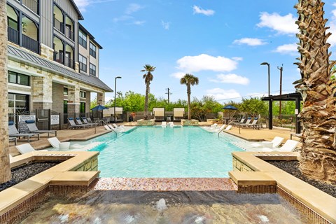 A large pool surrounded by palm trees and lounge chairs.