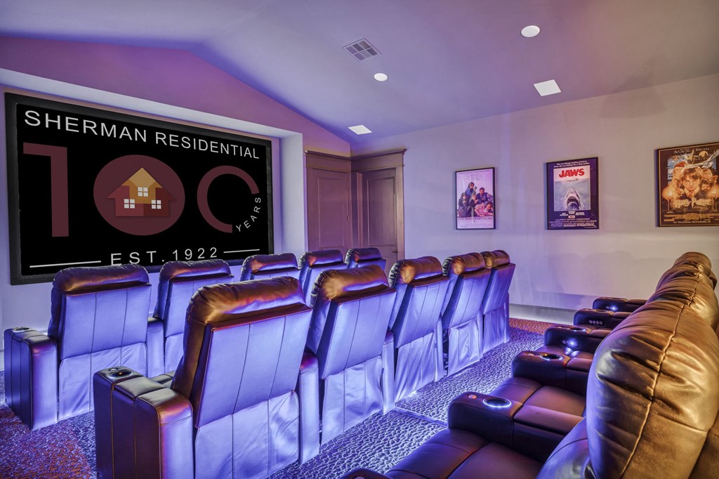 a theater room with leather chairs and a poster on the wall