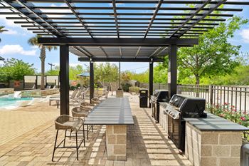 A patio with a table and chairs under a pergola.