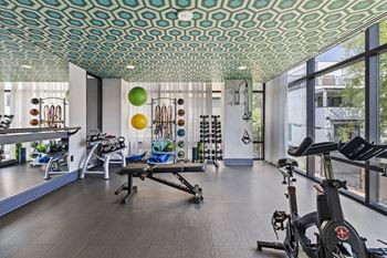 a workout room with exercise equipment and large windows