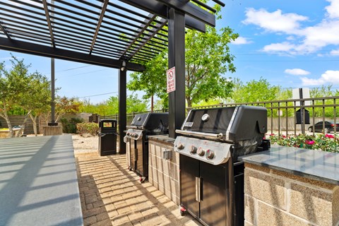 A BBQ grill area with a sign on a pole.