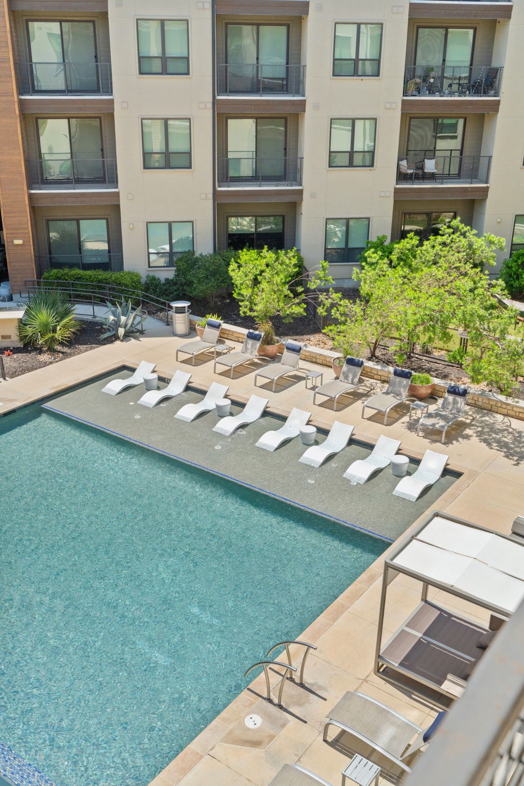 A large swimming pool surrounded by sun loungers and chairs.