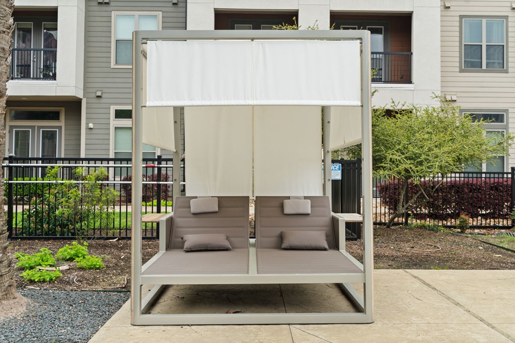 A white canopy is over a grey couch.