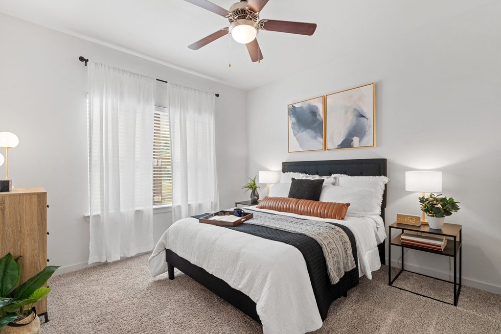 a bedroom with a bed and a ceiling fan