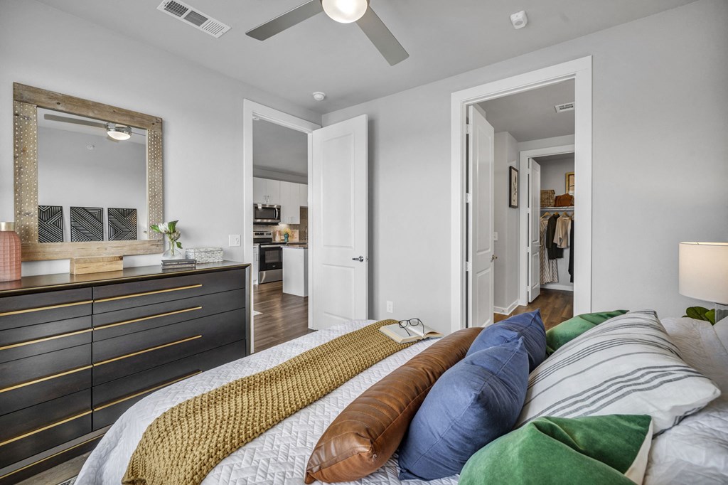 a bedroom with a large bed and a dresser with a mirror