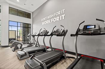 A gym with treadmills and a wall that says "Don't wish for it, work for it".