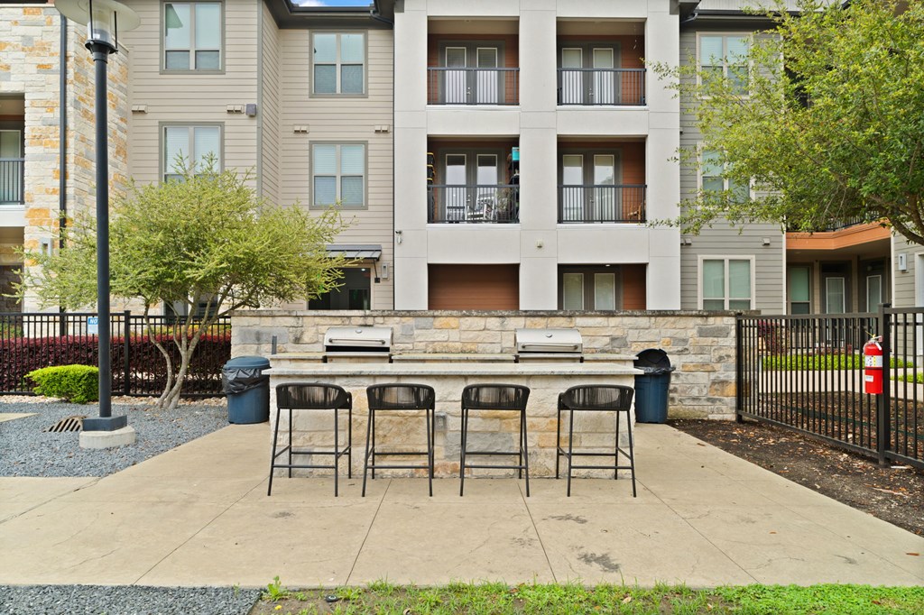 A patio with a table and chairs is in front of a building.