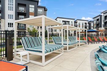 an outdoor pool with lounge chairs and umbrellas at the choices at trinity