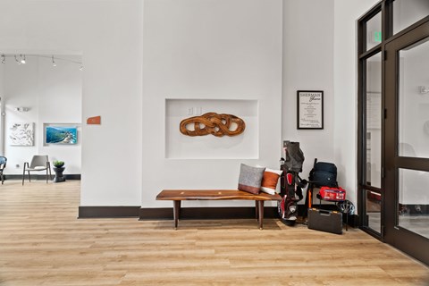 A room with a bench and a painting on the wall.