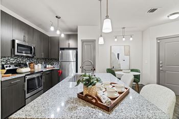 A modern kitchen with granite countertops and stainless steel appliances.