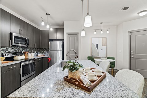A modern kitchen with granite countertops and stainless steel appliances.