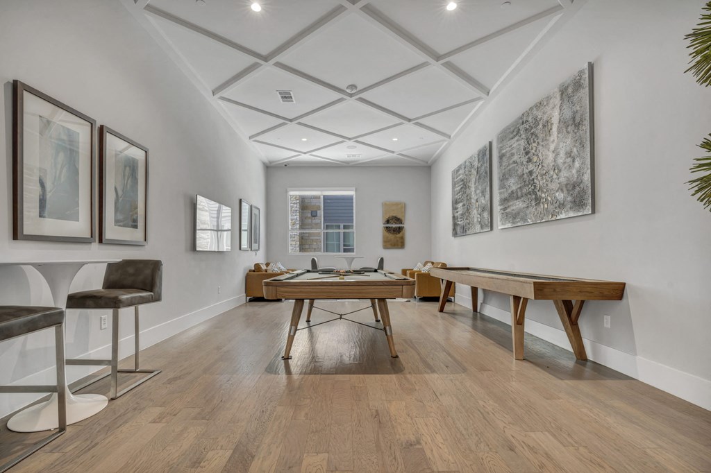 a game room with a ping pong table and chairs