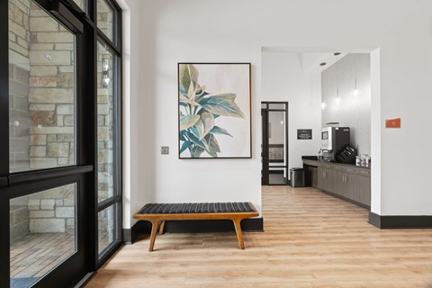 A room with a wooden bench and a painting on the wall.