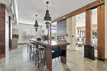 the kitchen has a large island with stools and a stone fireplace