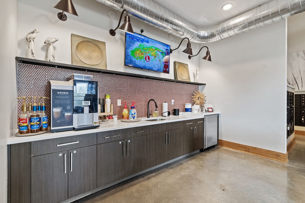 a bar area with a coffee machine and a tv on the wall