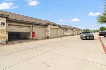 A parking lot with a black car and a silver car.