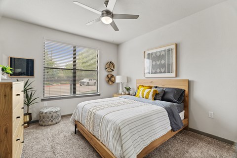 A bedroom with a bed, nightstand, and window.