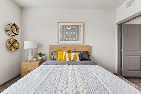A bedroom with a large bed and a wooden nightstand.