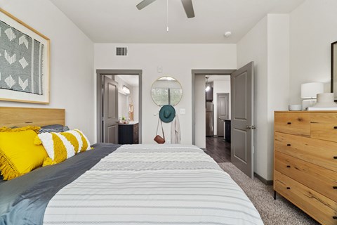 A bedroom with a bed, dresser, and mirror.