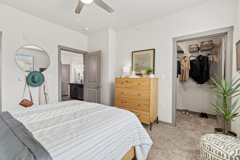 A bedroom with a bed, dresser, and mirror.