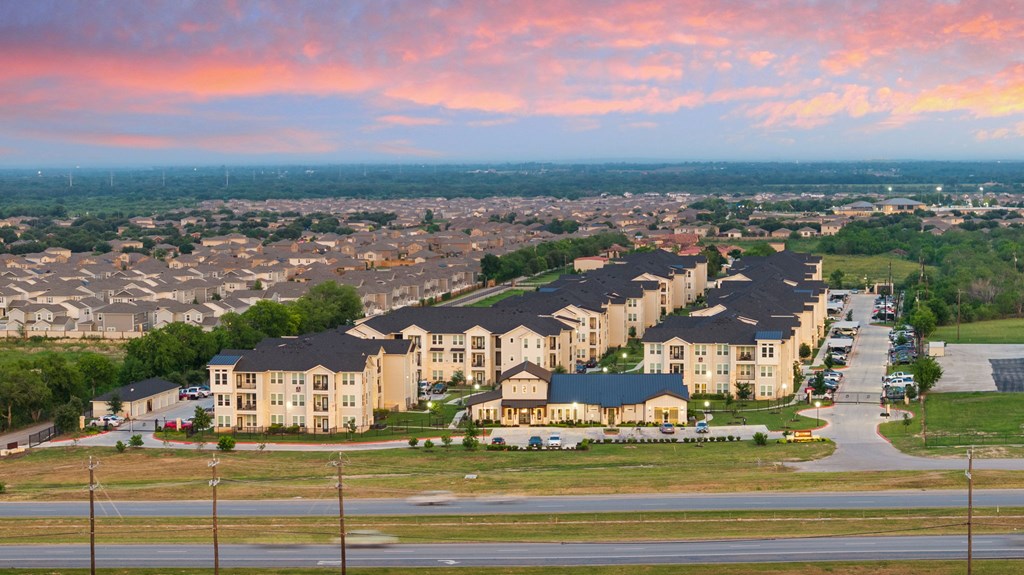 A large housing development with multiple houses and a parking lot.
