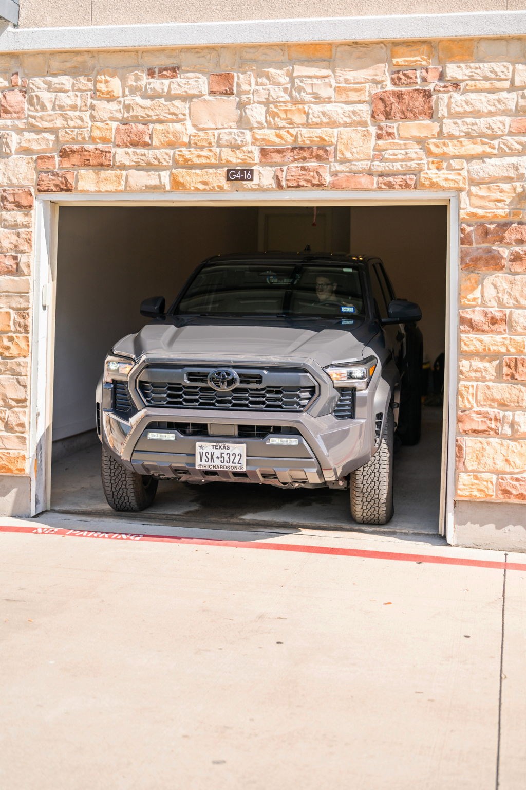 A grey Toyota 4x4 is parked in a garage.