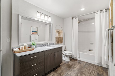 A bathroom with a wooden floor and white walls.