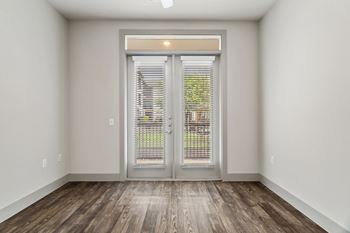 A room with a wooden floor and a sliding glass door.