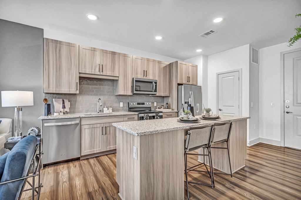 a kitchen with a large island with bar stools