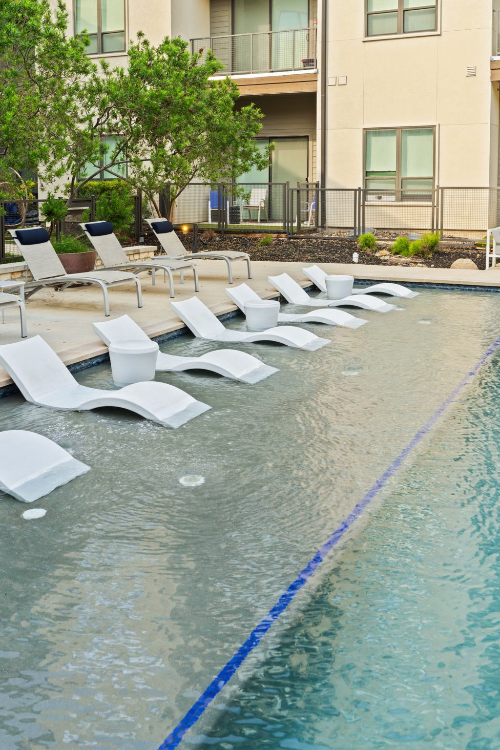 A pool with white chairs and a blue line in the middle.