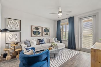 A living room with a blue chair and a white couch.