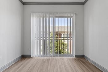 a living room with white walls and a large window with white blinds