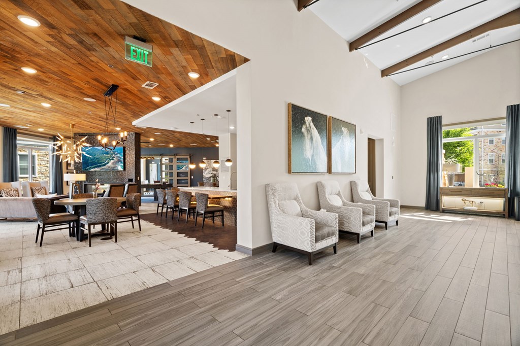 A room with a wooden ceiling and floor, a white couch, and a painting on the wall.