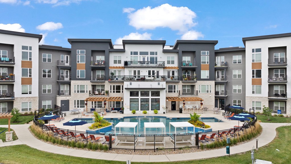an exterior view of an apartment building with a swimming pool